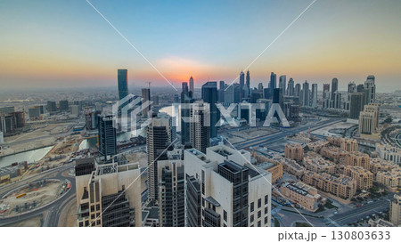 Aerial view of a big modern city with sunset timelapse. Business bay, Dubai, United Arab Emirates. Aerial view of a big modern city with sunset timelapse. Business bay, Dubai, United Arab Emirates. 130803633