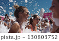 Smiling friends enjoying a lively foam party under the bright summer sun 130803752