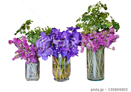 Blooming pink statice flower and violet orchid bouquet in clear glass vase isolated on white background with clipping path 130804803