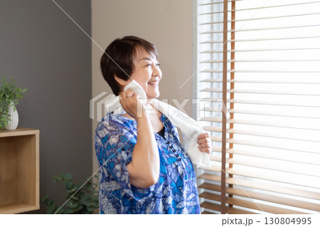 タオルで汗を拭う笑顔の60代のシニア女性 上半身 タオルで汗を拭う笑顔の60代のシニア女性 上半身 130804995