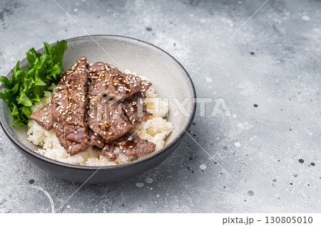 Delectable yakiniku feast, featuring a variety of marbled beef cuts and rice. A culinary journey that captures the essence of Japanese grilling traditions. grey background. top view 130805010