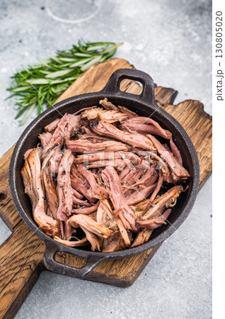 Savory pulled beef brisket served in a skillet, dipping creating an appealing and mouthwatering culinary scene. grey background. top view 130805020