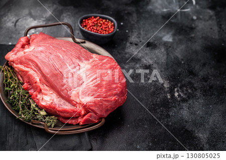 Raw Top Round beef meat cut, topside with hrebs for roast. black background. Top view 130805025