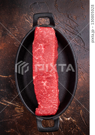 Tender wagyu loin, displaying its luscious fat distribution and deep color. An exquisite ingredient for creating unforgettable meals at home. brown background. top view Tender wagyu loin, displaying its luscious fat distribution and deep color. An exquisite ingredient for creating unforgettable meals at home. brown background. top view 130805028