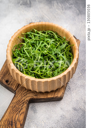 Fresh arugula leaves, vibrant and peppery, perfect for adding a zesty touch to salads and sandwiches. grey background. top view 130805036