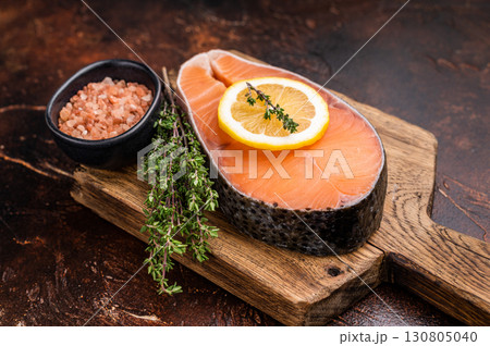 Exquisite raw salmon chop, showcasing its vibrant hue and tenderness. Ideal for a healthy dinner or an elegant sushi platter presentation. brown background. top view Exquisite raw salmon chop, showcasing its vibrant hue and tenderness. Ideal for a healthy dinner or an elegant sushi platter presentation. brown background. top view 130805040
