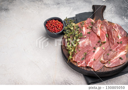Guanciale dried speck ham, pork cured meat on wooden board. grey background. top view 130805050