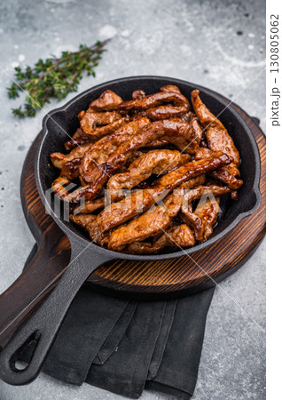 Delicious glazed teriyaki beef in a skillet. grey background. top view 130805062