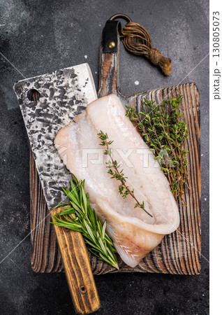 Freshly cut cod fish fillet, highlighting its mild taste and versatility in various dishes. black background. top view 130805073