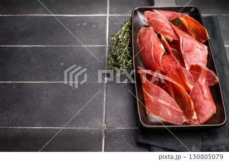 Dry cured and smoked serrano ham, pork meat. black background. top view 130805079