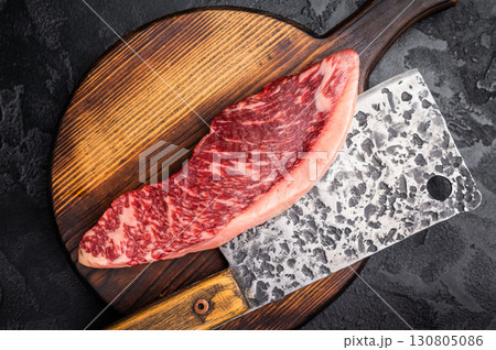 Freshly sourced picanha cut or rump cap steak, raw meat waiting to be transformed into a mouthwatering dish. black background. top view Freshly sourced picanha cut or rump cap steak, raw meat waiting to be transformed into a mouthwatering dish. black background. top view 130805086