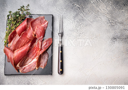Sliced Speck bacon, Italian cured meat. grey background. top view 130805091