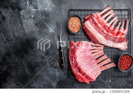 Raw rack of lamb, fresh mutton meat for chops cutlets. black background. top view Raw rack of lamb, fresh mutton meat for chops cutlets. black background. top view 130805109