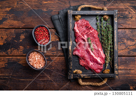 Uncooked hanging tender beef steak, Hanger steak in wooden tray with herbs. wooden background. top view 130805111