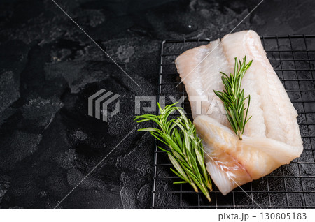 Uncooked Atlantic cod fillet, raw fish ready to be seasoned and transformed into a delicious meal. black background. top view Uncooked Atlantic cod fillet, raw fish ready to be seasoned and transformed into a delicious meal. black background. top view 130805183