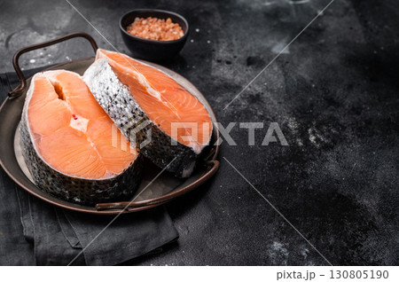 Fresh raw salmon fillet, glistening with moisture, ready for marinating or grilling. A perfect choice for healthy seafood lovers. black background. top view Fresh raw salmon fillet, glistening with moisture, ready for marinating or grilling. A perfect choice for healthy seafood lovers. black background. top view 130805190