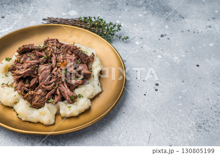 Homemade French Beef Bourguignon Stew on a plate with mashed potatoes. grey background. top view Homemade French Beef Bourguignon Stew on a plate with mashed potatoes. grey background. top view 130805199