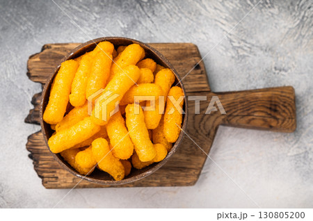 Irresistible Cheese puffs, cheese snacks bursting with bold flavors and a satisfying crunch. grey background. top view 130805200