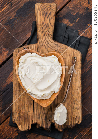 Traditional Mascarpone cheese in wooden bowl. wooden background. top view Traditional Mascarpone cheese in wooden bowl. wooden background. top view 130805241