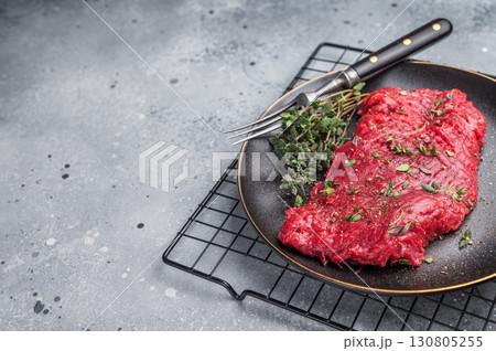 Marinated Skirt machete steak, raw beef meat with thyme and spices on plate. grey background. top view 130805255