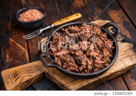 Traditional Barbecue smoked beef meat, pulled beef in a skillet. wooden background. top view Traditional Barbecue smoked beef meat, pulled beef in a skillet. wooden background. top view 130805265