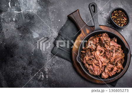 Traditional barbecue pulled beef, Slow cooked meat cooked in a smoker. black background. top view Traditional barbecue pulled beef, Slow cooked meat cooked in a smoker. black background. top view 130805273