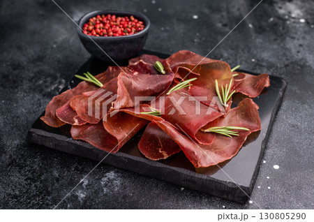 Dried spanish meat slices cecina, spanish tapa. black background. top view 130805290
