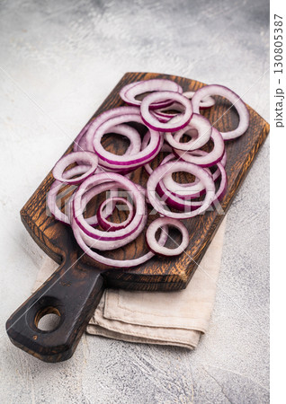 Sliced rings of red onion or purple onion. grey background. top view Sliced rings of red onion or purple onion. grey background. top view 130805387