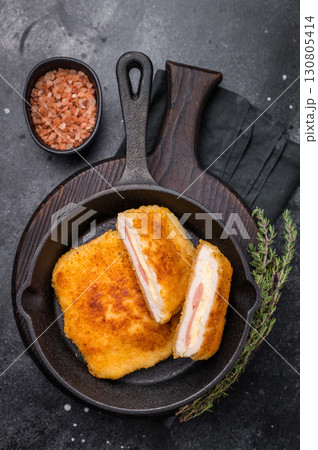 Fried cordon bleu cutlet with cheese and ham in pan. black background. top view 130805414