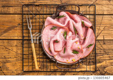 Mortadella sausage slices with pistachios for sandwiches in steel tray. wooden background. top view 130805467