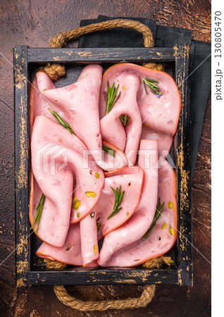 Mortadella Bologna slices with pistachios for breakfast in wooden. brown background. top view Mortadella Bologna slices with pistachios for breakfast in wooden. brown background. top view 130805470