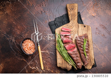 Grilled Lamb tenderloin steak, roast mutton fillet meat with herbs. brown background. top view 130805510