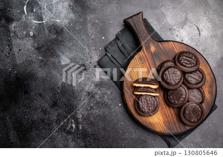 Jaffa Cookies covered with chocolate and filled with jam on wooden board. black background. top view 130805646