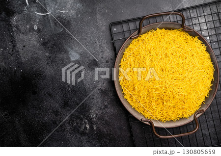 Raw Vermicelli, uncooked pasta in a tray. black background. top view Raw Vermicelli, uncooked pasta in a tray. black background. top view 130805659
