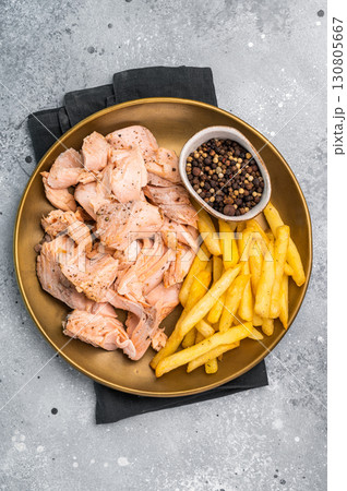 Dinner with Pulled salmon roast fillets and french fry on a plate. gray background. Top view Dinner with Pulled salmon roast fillets and french fry on a plate. gray background. Top view 130805667