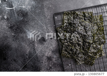Dried Nori seaweed sheets on a rack. black background. top view Dried Nori seaweed sheets on a rack. black background. top view 130805677