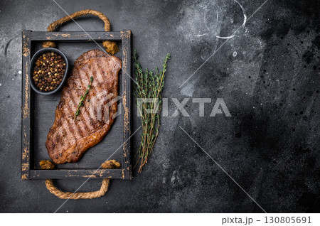 BBQ roast New York strip steak, striploin beef meat steak. black background. top view 130805691
