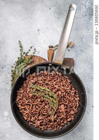 Frying Pan with fried mince beef meat, fresh cooked forcemeat. grey background. top view 130805692