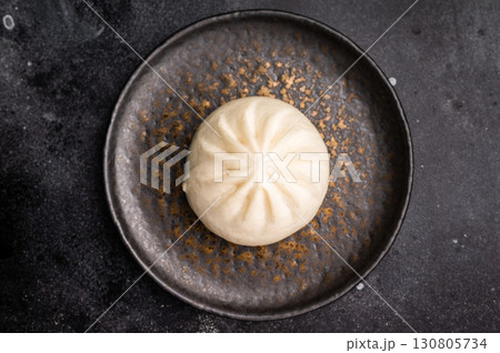 Chinese Steam Bao bun with meat on plate with chopsticks. black background. top view 130805734