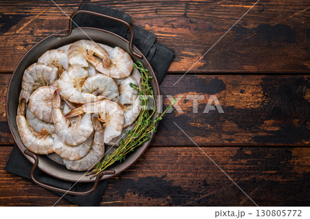 Uncooked Raw white tiger shrimps prawns in a tray. Top view. Wooden background 130805772