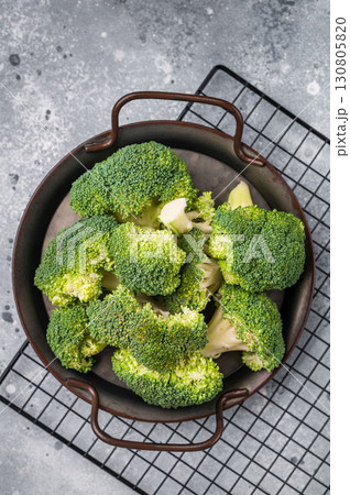 Green fresh broccoli pieces in a steel tray. grey background. top view 130805820