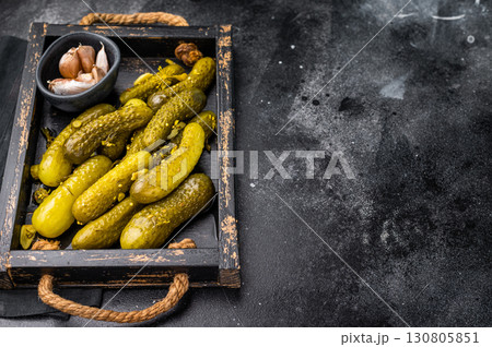 Sweet and tangy pickled cucumbers, ideal for enhancing burgers and wraps with a burst of flavor. black background. top view Sweet and tangy pickled cucumbers, ideal for enhancing burgers and wraps with a burst of flavor. black background. top view 130805851