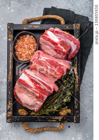 Fresh Raw lamb rib cuts, mutton meat with rib bone in wooden board. grey background. top view 130805938