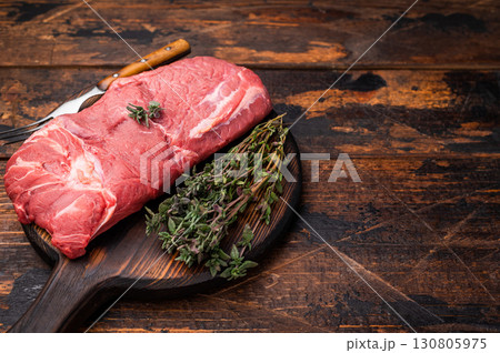Vibrant raw horse meat on a rustic wooden surface, highlighting its rich color and fine marbling, ideal for unique culinary dishes. wooden background. top view 130805975