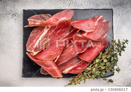 Sliced Speck bacon, Italian cured meat. grey background. top view Sliced Speck bacon, Italian cured meat. grey background. top view 130806017