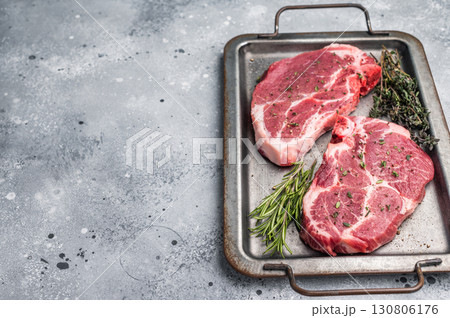 Raw pork neck meat steaks on steel tray. grey background. top view Raw pork neck meat steaks on steel tray. grey background. top view 130806176