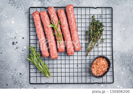 Raw beef and lamb meat kebabs sausages, kofta kebab. grey background. top view Raw beef and lamb meat kebabs sausages, kofta kebab. grey background. top view 130806200