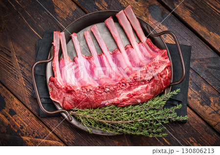 Fresh rack of lamb, raw mutton meat for chops steaks on steel tray. wooden background. top view 130806213