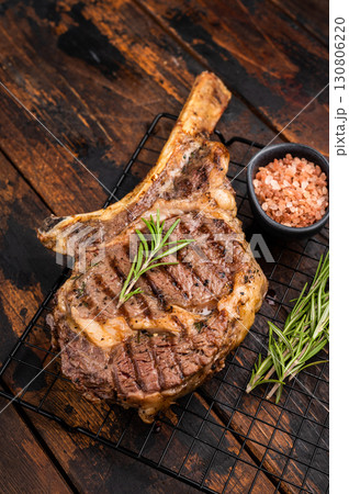 Grilled Tomahawk beef steak, cooked rib eye with bone. wooden background. top view Grilled Tomahawk beef steak, cooked rib eye with bone. wooden background. top view 130806220