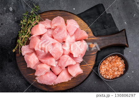 Sliced turkey fillet cubes, diced poultry breast meat. black background. top view Sliced turkey fillet cubes, diced poultry breast meat. black background. top view 130806297